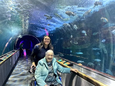 A resident and staff member at an aquarium exhibit