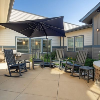 Outdoor seating area with rocking chairs and umbrella