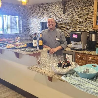 A chef smiling behind a food display at the facility