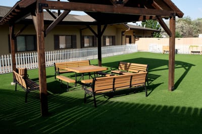 Outdoor seating area with tables and chairs under a canopy