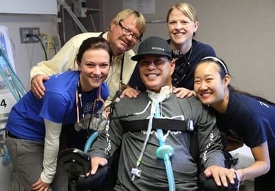 Staff smiling with a resident in a care facility