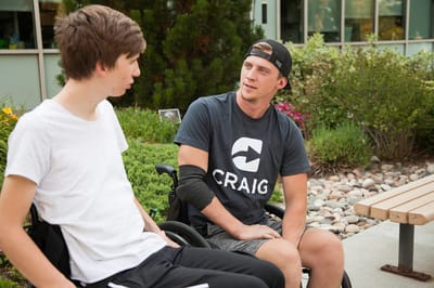 Two young men chatting in a garden area