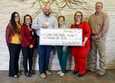 Staff members presenting a check for $10,000