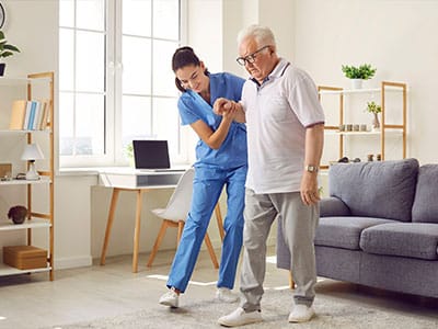 Care staff assisting a resident in a cozy living room