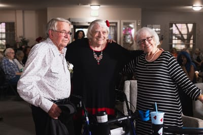 Three residents smiling together in a common area