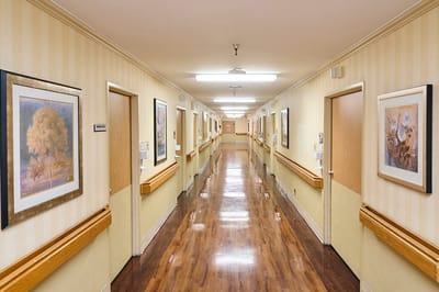 Interior hallway with framed artwork and polished wood floors