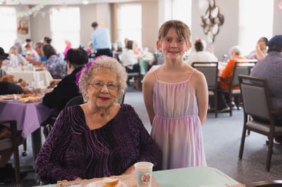 A woman and a girl seated in a common area during an event
