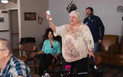 Senior resident engaging in an activity with staff and others