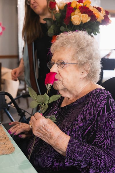 Resident enjoying a rose in a common area