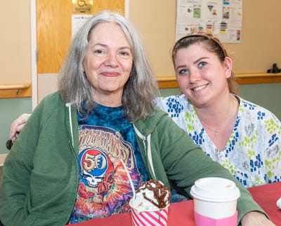 Resident enjoying ice cream with staff member