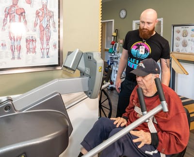 A staff member assisting a resident during exercise therapy