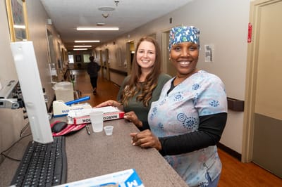 Staff members smiling in a facility hallway