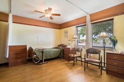 A well-lit private resident room with furniture