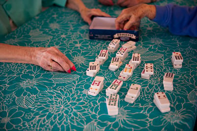 Residents playing dominoes at a table