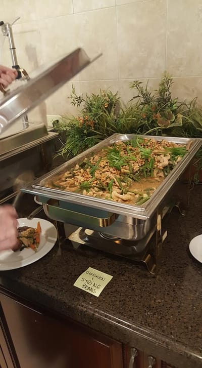 Residents being served a hot meal in the dining area