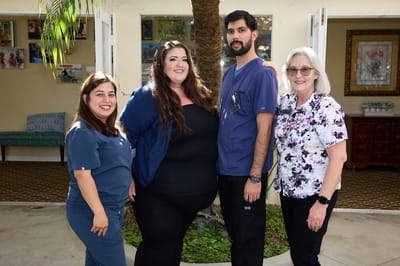 Staff members posing outdoors near the facility entrance