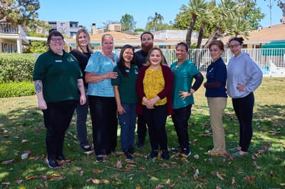 Staff members posing together in an outdoor setting