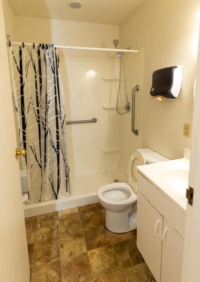 Clean bathroom with shower and grab bars