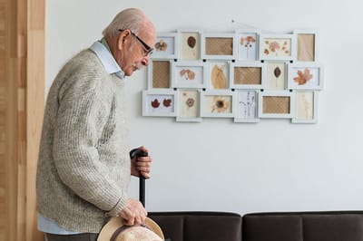 Senior resident with a cane in a cozy interior setting