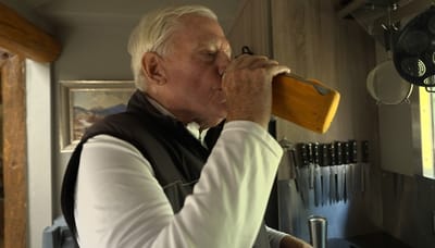 Senior man enjoying a drink in the kitchen