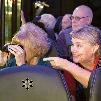 Residents enjoying a bus outing, looking through binoculars