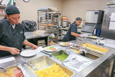 Staff preparing meals in a kitchen setting
