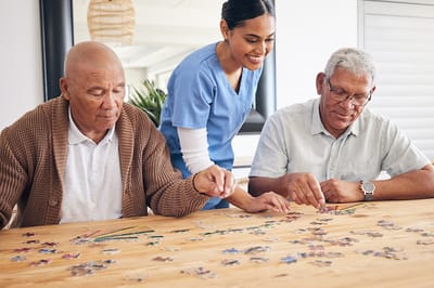 Residents and staff engaged in a puzzle activity