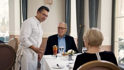 Server interacting with diners in the dining room