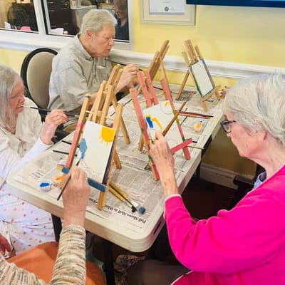 Residents painting at a communal activity table
