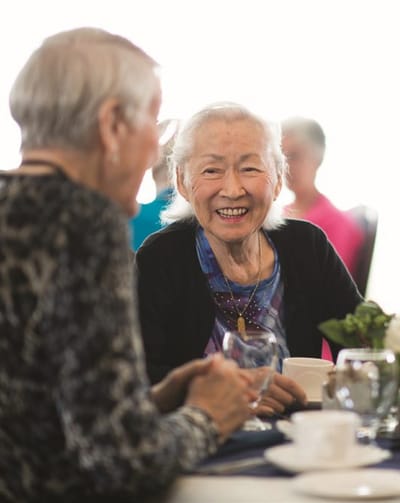 Residents enjoying conversation at a dining table