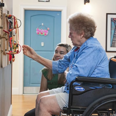 Resident engaging with an activity under staff guidance