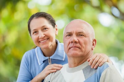 A caregiver with a resident in a garden setting