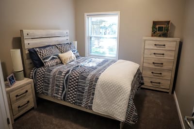 Cozy private resident room with a bed and dresser