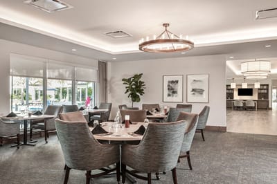 Bright dining room with modern decor and tables set for meals