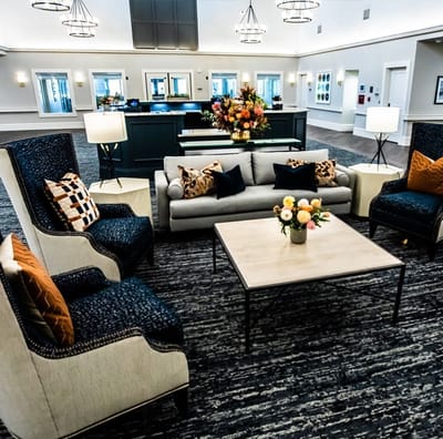 Brightly furnished common area with seating and floral arrangements