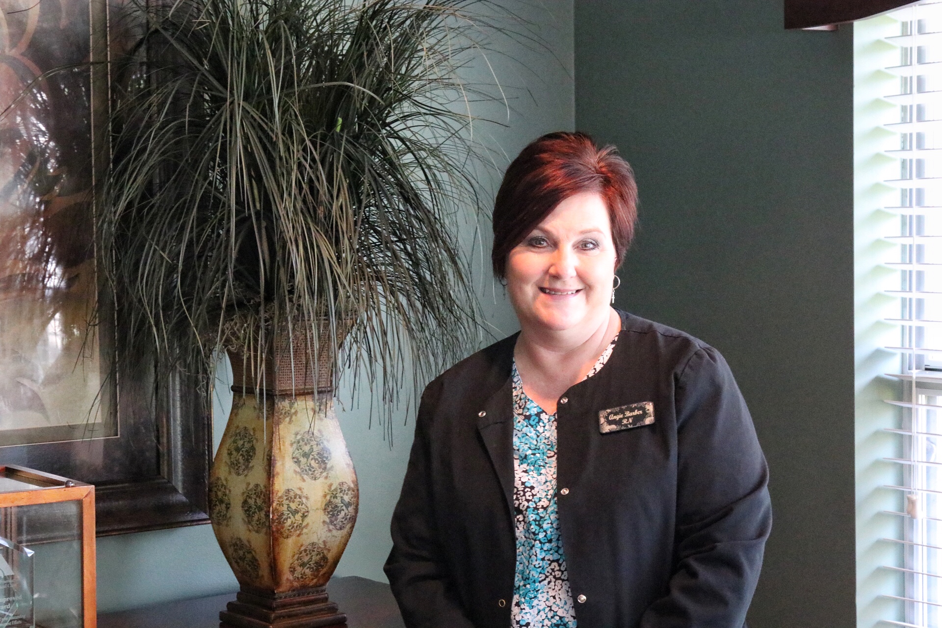 Staff member smiling in a well-decorated room