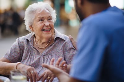 Resident interacting with staff in a lively outdoor setting
