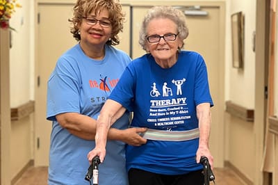 Staff assisting a resident in a hallway