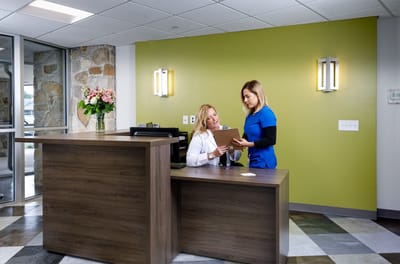 Staff assisting a resident at the reception area
