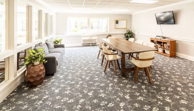 Bright and spacious common area with seating and a dining table
