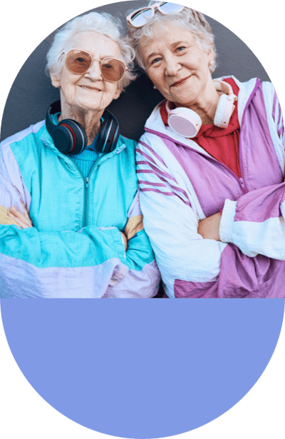 Two smiling seniors wearing headphones outdoors