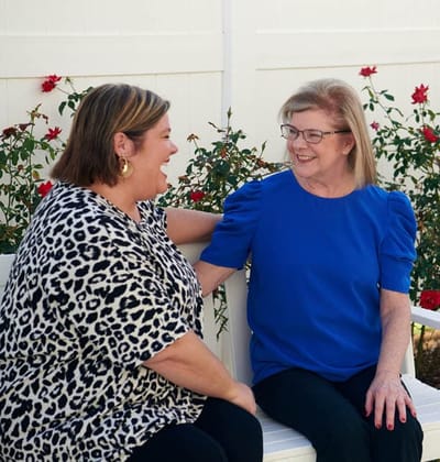 Two women enjoying a moment in a garden setting