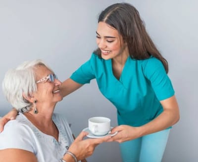 Healthcare worker serving tea to an elderly resident