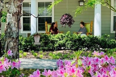 Two residents enjoying conversation on a porch