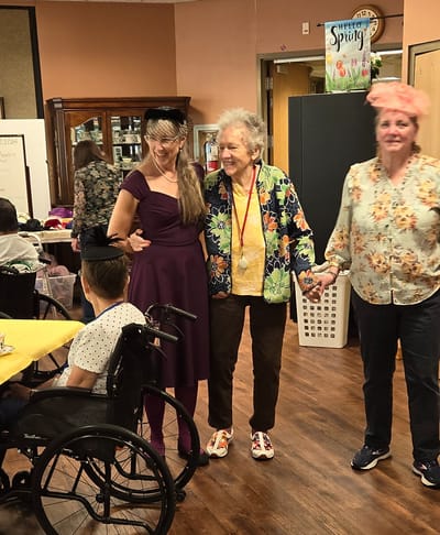 Residents participating in a lively activity with staff assistance