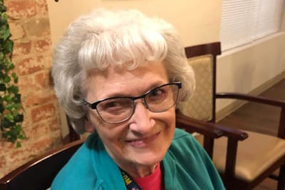 A smiling resident in a cozy lounge area