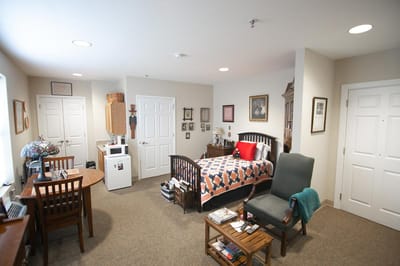 A private resident room with a bed and table