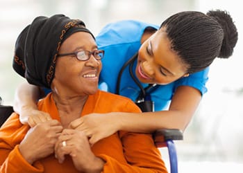 Enterprise Health & Rehabilitation Center, Nursing Home in Enterprise, AL — Caregiver interacting with a smiling senior woman