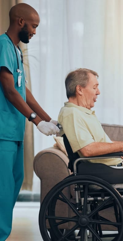 A caregiver assisting a resident in a wheelchair