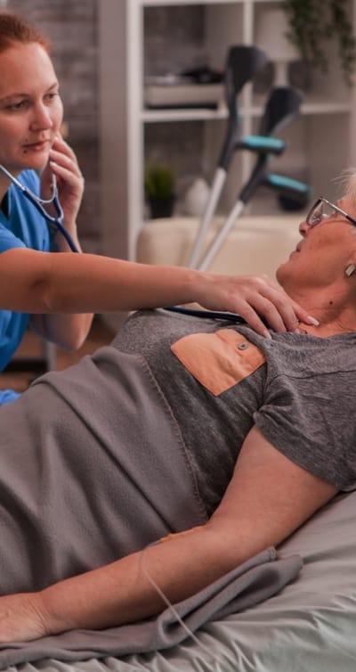 A caregiver checking the heartbeat of an elderly resident